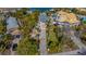 Aerial view of a waterfront home with construction materials in the driveway and a view of adjacent properties at 410 140Th E Ave, Madeira Beach, FL 33708