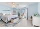 Spacious blue bedroom with ceiling fan, seating area, and plush carpet at 410 140Th E Ave, Madeira Beach, FL 33708