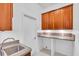 Laundry room with wood cabinets, countertop, and utility sink at 5012 76Th E St, Bradenton, FL 34203