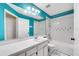 Bathroom with turquoise walls, white fixtures, and a tub/shower combo at 711 Chilt Dr, Brandon, FL 33510