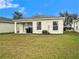 The backyard features a grassy area and a sliding glass door that provides access to the interior of the home at 7833 Carriage Pointe Dr, Gibsonton, FL 33534