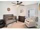 Cozy Bedroom features neutral walls, a ceiling fan, a crib and a comfortable chair at 7833 Carriage Pointe Dr, Gibsonton, FL 33534