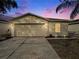 Inviting house exterior featuring a two-car garage and landscaped yard at 7833 Carriage Pointe Dr, Gibsonton, FL 33534