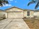 The home has a two-car garage, a well-maintained lawn, and attractive landscaping, enhancing curb appeal at 7833 Carriage Pointe Dr, Gibsonton, FL 33534