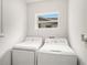 Functional laundry room with a window and a washing machine and dryer set against a neutral backdrop at 7833 Carriage Pointe Dr, Gibsonton, FL 33534