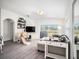 Bright living room with modern decor, gray plank floors, large windows, and sliding glass doors to the backyard at 7833 Carriage Pointe Dr, Gibsonton, FL 33534