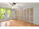 Bright bedroom with wood flooring, large closet, and window with curtains at 4042 Boulder Dr, New Port Richey, FL 34653