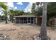 Home exterior showcasing a screened porch and a gravel yard at 4042 Boulder Dr, New Port Richey, FL 34653