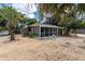 House with a screened porch, gravel yard, and palm trees at 4042 Boulder Dr, New Port Richey, FL 34653