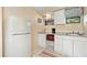 Small galley kitchen with granite countertops, microwave, and refrigerator at 4042 Boulder Dr, New Port Richey, FL 34653