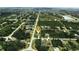 Aerial view of a house in a residential area with surrounding houses and greenery at 141 Hobo Rd, Rotonda West, FL 33947