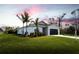 Single-story house with a light-colored exterior, palm trees, and a grassy lawn at 141 Hobo Rd, Rotonda West, FL 33947