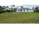 Rear view of a single-story home with a large backyard at 141 Hobo Rd, Rotonda West, FL 33947