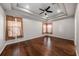 Bright bedroom featuring hardwood floors, ceiling fan, and natural light from the windows at 4205 Morning Breeze Ct, Tampa, FL 33619