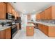 Well-equipped kitchen with stainless steel appliances, wood cabinets, and a large island at 4205 Morning Breeze Ct, Tampa, FL 33619
