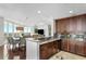 Open kitchen with dark wood cabinets, granite countertops, and stainless steel appliances at 450 Knights Run Ave # 1102, Tampa, FL 33602