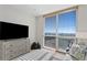 Living room area with a large television, a dresser, and a comfortable armchair at 450 Knights Run Ave # 1102, Tampa, FL 33602
