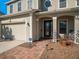 Close-up view of the home's entrance, featuring a double door, charming porch decor, and landscaping at 5056 Inshore Landing Dr, Apollo Beach, FL 33572