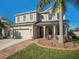 Welcoming front exterior of a two-story home with a brick walkway and lush landscaping at 5056 Inshore Landing Dr, Apollo Beach, FL 33572