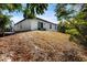 View of backyard, trees, and the home's exterior at 5193 Deltona Blvd, Spring Hill, FL 34606