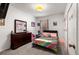 Bright bedroom with a dark dresser and colorful striped bedding at 5193 Deltona Blvd, Spring Hill, FL 34606
