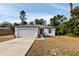 Newly constructed home with a white exterior, two-car garage, and landscaped yard at 5193 Deltona Blvd, Spring Hill, FL 34606