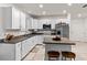 Modern kitchen with white cabinets, stainless steel appliances, and an island with seating at 5193 Deltona Blvd, Spring Hill, FL 34606