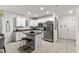 Well-lit kitchen featuring white cabinetry, stainless steel appliances, and a central island with bar stools at 5193 Deltona Blvd, Spring Hill, FL 34606