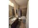 Bathroom with a shower-tub combo, framed mirror, and wood-look tile flooring at 8451 Karpeal Dr, Sarasota, FL 34238