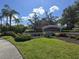 A welcoming community sign at Palmer Oaks is surrounded by lush landscaping under a clear sky at 8451 Karpeal Dr, Sarasota, FL 34238
