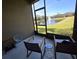 Relaxing screened-in porch with a scenic lake view and comfortable seating at 8451 Karpeal Dr, Sarasota, FL 34238