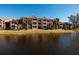 Apartment buildings line a tranquil pond, reflecting the clear blue sky at 10200 Gandy N Blvd # 1313, St Petersburg, FL 33702