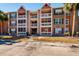 View of a two-story apartment building with balconies, palm trees, and a walkway at 10200 Gandy N Blvd # 1313, St Petersburg, FL 33702
