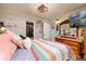 Main bedroom with a colorful quilt, wooden dresser, and TV at 10200 Gandy N Blvd # 1313, St Petersburg, FL 33702