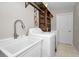 Bright laundry room, featuring a utility sink, washer, dryer, and ample shelving at 10463 Wren Rd, Brooksville, FL 34613