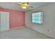 Simple bedroom with ceiling fan and pink walls at 1535 Council Dr, Sun City Center, FL 33573