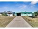 Mint green house with carport and landscaped yard at 1535 Council Dr, Sun City Center, FL 33573