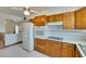 Kitchen boasts wood cabinets, white appliances, and a breakfast bar at 1535 Council Dr, Sun City Center, FL 33573