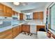 Kitchen with wood cabinets, white appliances, and a breakfast bar at 1535 Council Dr, Sun City Center, FL 33573