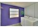 Laundry room with washer, dryer, and purple walls at 1535 Council Dr, Sun City Center, FL 33573