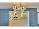 Open concept living room with chandelier and kitchen view at 1535 Council Dr, Sun City Center, FL 33573