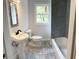 Updated bathroom with pedestal sink, grey tile shower, and patterned floor tiles at 1714 2Nd E Ave, Bradenton, FL 34208