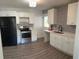 Modern kitchen featuring white cabinets, stainless steel appliances, and patterned tile backsplash at 1714 2Nd E Ave, Bradenton, FL 34208