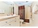 Clean bathroom with tub shower, vanity, and brown accents at 19811 Gulf Blvd # 102, Indian Shores, FL 33785
