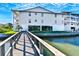 Building exterior with a wooden walkway leading to the water at 19811 Gulf Blvd # 102, Indian Shores, FL 33785