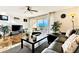 Living room with water view, leather couch, and large TV at 19811 Gulf Blvd # 102, Indian Shores, FL 33785
