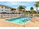 Community pool with lounge chairs and surrounding tropical landscaping at 19811 Gulf Blvd # 102, Indian Shores, FL 33785