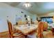 Traditional dining room featuring a ceiling fan and seating for six with access to the living area and outdoor views at 3055 Casa Del Sol Cir # 303, Clearwater, FL 33761