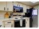 Traditional kitchen with white cabinetry, appliances and countertops at 3055 Casa Del Sol Cir # 303, Clearwater, FL 33761