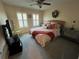 Spacious bedroom with coral bedding, a ceiling fan, and window shutters at 3638 Trafalgar Way # 102, Palm Harbor, FL 34685